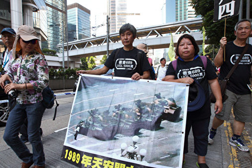 Người biểu tình cầm theo bức ảnh Vương Duy Lâm đứng ngăn cản xe tăng.