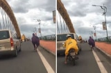Hình ảnh đẹp: Tài xế ôtô đi chậm lại để chắn gió cho người phụ nữ đạp xe qua cầu Rồng