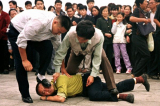 Cảnh sát bắt giữ một người biểu tình Pháp Luân Công tại Quảng trường Thiên An Môn ở Bắc Kinh vào ngày 1/10/2000.