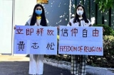 Hai chị em song sinh cầm biểu ngữ giải cứu cha trước LSQ Trung Quốc ở Sydney